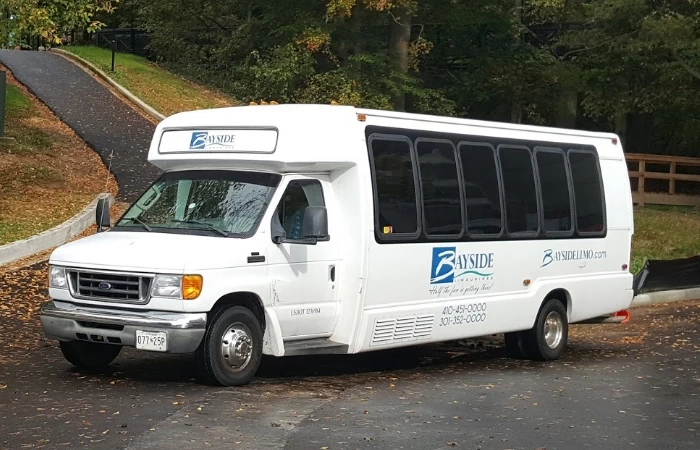 White 24 passenger Ford shuttle bus.