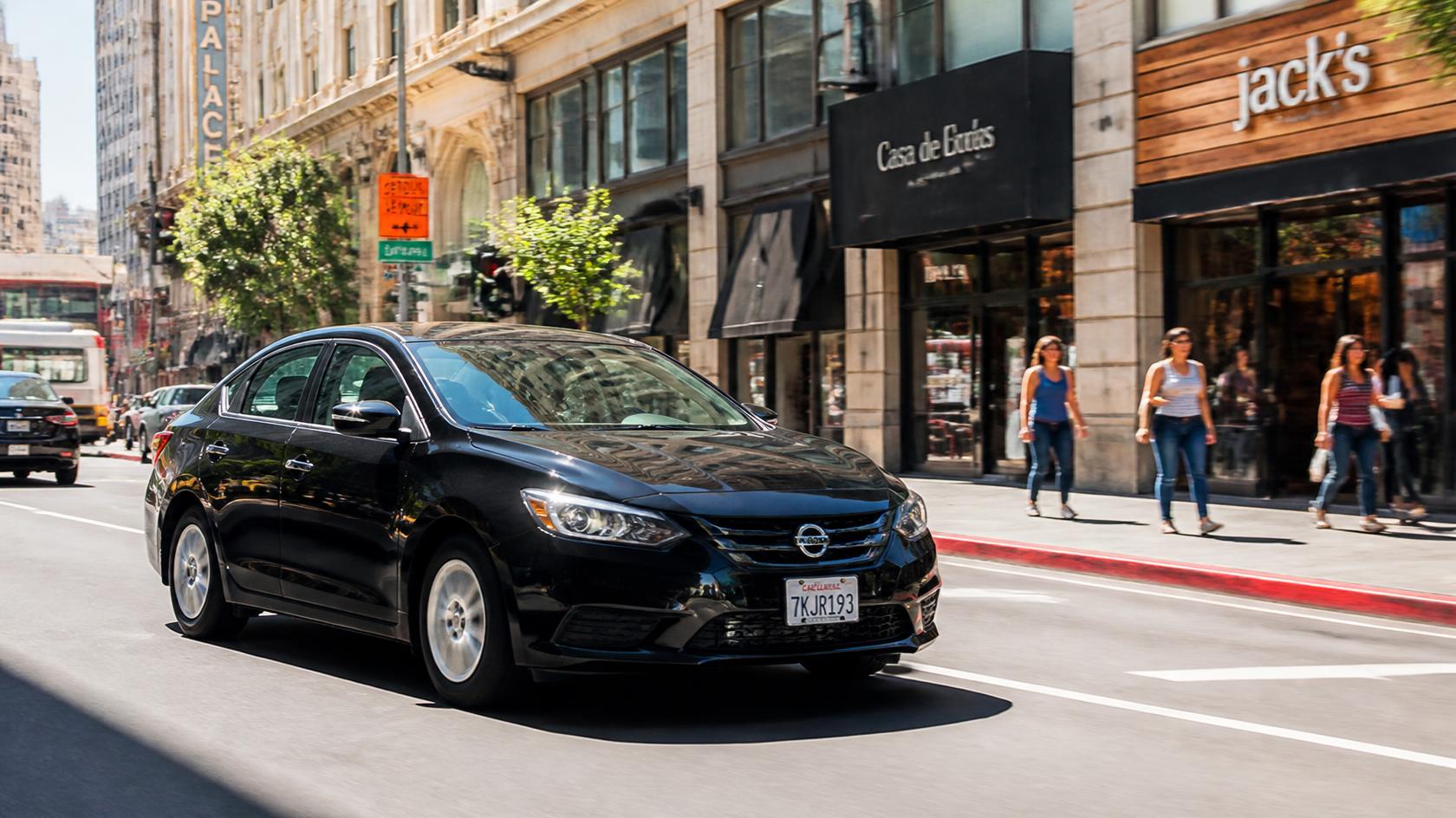 Black sedan chauffeur drop-off near a busy downtown Frederick street event